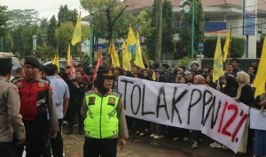 Demonstran melakukan aksi dengan membentangkan spanduk bertuliskan Tolak PPN 12%. (Aden/Fokuspers)